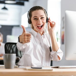 Female cheerful customer support representative showing thumbs up wearing the headset