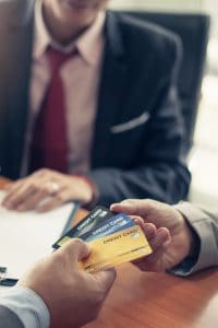 Close up view of a man handing over credit cards